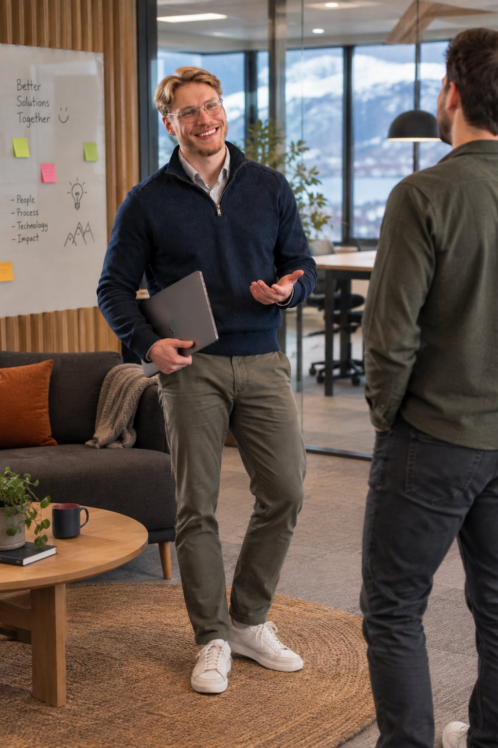 Niklas i samtale med en kunde i et lyst kontorlokale, med bærbar PC under armen